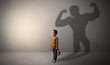 © ra2 studio - Little waggish boy in an empty room with musclemen shadow behind