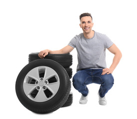 Wall Mural - Young man with car tires on white background