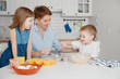 © Parilov - Family cooking. Children and mom prepare cupcakes. They laugh and smile, homemade cakes.