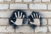 Imprint Of Two Hands On A Brick Wall.