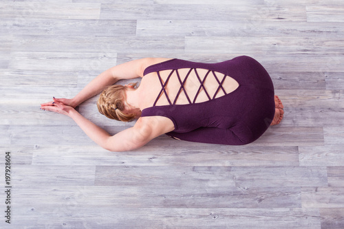 Fotografie, Obraz Stylish yoga teacher in purple overall doing yoga asanas