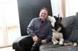 © 977_rex_977 - a laughing man with a Husky on a sofa at home