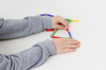 The child plays with a magnetic designer