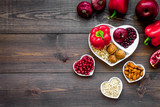 Fototapeta Zwierzęta - Food which help heart stay healthy. Vegetables, fruits, nuts in heart shaped bowl on dark wooden background top view copy space
