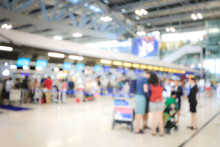 Blurred Image Of Airport Check-in Counters With Passengers And Crowd Of People Control Barriers With Bokeh In International Airport, Que, Travel, Tourism, Business Concept Abstract Blur Background.