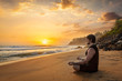 © Dmitry Rukhlenko - Young sporty fit man doing yoga meditating on tropical beach