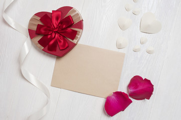 Mockup Letter with a gift in the form of a heart and a petals of roses. greeting card for Valentines Day with place for your text. Flat lay, top view photo mock up