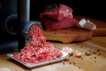 Minced Meat Coming Out From Grinder. Healthy Homemade Minced Meat. Dark Background. Horizontal View Photo. Place For Copyspace.