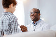 © Viacheslav Yakobchuk - Purpose of auscultation. Jovial pleased male doctor hearing boy while grinning and using stethoscope