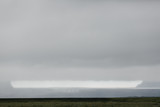 Fototapeta Na ścianę - spectacular icelandic landscape with grassy plain and glacier at cloudy day