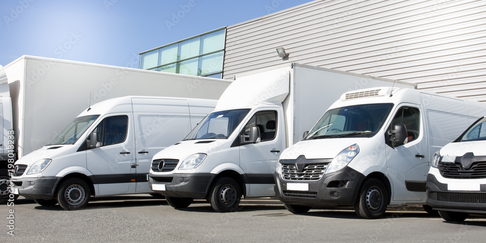 delivery white vans in service van trucks and cars in front of the entrance of a warehouse distribution logistic society - obrazy, fototapety, plakaty 