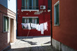 A street with hanging clothes in Burano, a little island near Venice, Italy