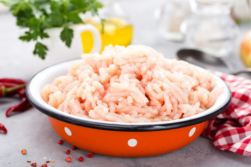 Canvas Print - Forcemeat. Raw ground chicken meat in bowl on white kitchen table. Fresh minced chicken breast meat