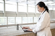 © Mint Images - Asian woman doctor working on a lap top in a hospital hallway.