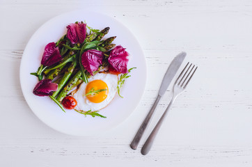 Wall Mural - Fried egg and roasted fresh asparagus in black plate