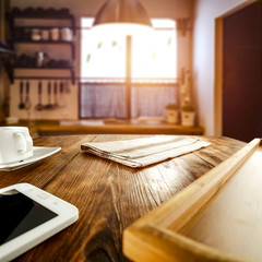 Wall Mural - a telephone and a cup and a cutting board and wooden tray on a kitchen table with copy space for pro