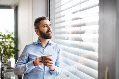 Fotomural A man by the window holding a cup of coffee. Smart home.