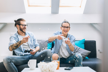 Wall Mural - Young couple playing video games at home. 