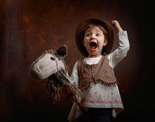 Cute Little Girl Dressed Like A Cowboy Playing With A Homemade Horse.