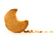 Peanut butter cookie on a white background. Golden homemade biscuit with a missing bite and trail of crumbs. A tempting snack.