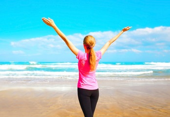 Fitness happy woman near the sea on the beach on a summer day