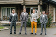 © Vladimir - .stylish groom together with the groom's friends stand near the house in rainy weather