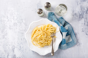 Wall Mural - Cacio e Pepe - pasta spaghetti with pecorino cheese and pepper. Healthy italian traditional food concept with copy space. Overhead shot, top view.