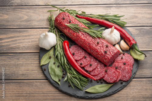 Zdjęcie XXL Kiełbasa z salami z rozmarynem i warzywami. Widok z góry, z pustą przestrzenią pod napisem lub reklamą.