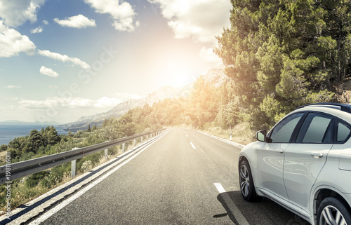 Fotomural A white car rushing along a high-speed highway in the sun.