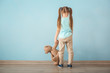 © Africa Studio - Lonely little girl with teddy bear near color wall. Autism concept