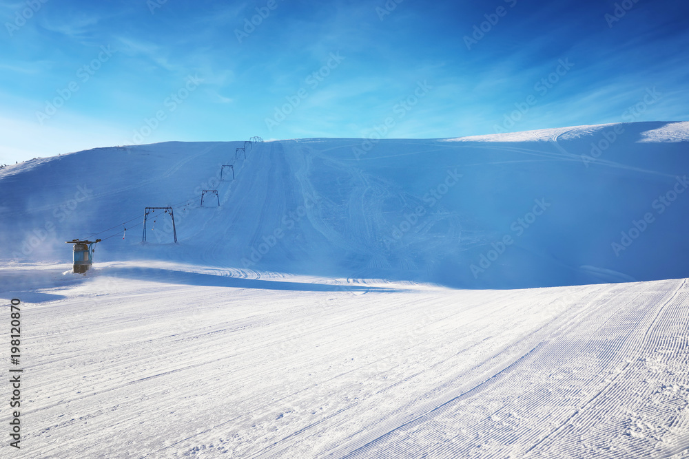 Ski slope at snowy resort on winter day