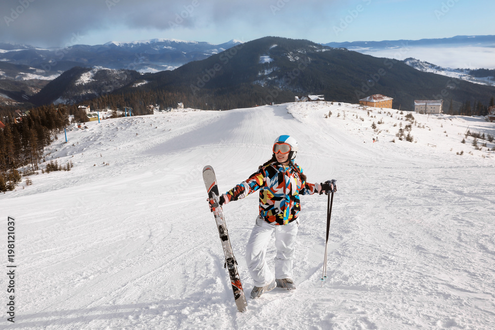 Woman on ski piste at snowy resort. Winter vacation