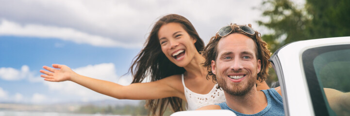 Wall Mural - Car road trip travel fun young couple driving on summer vacation freedom banner. Happy free people in convertible cabriolet. Asian woman carefree with open arms joyful. Friends going on road trip.