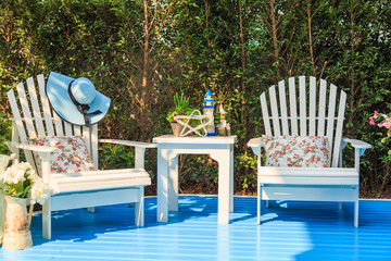 Wall Mural - A white coffee table and wooden chairs in the garden.