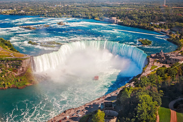 aerial top landscape view of niagara falls and tour boat in water between us and canada. horseshoe o
