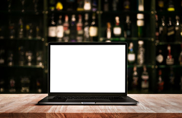 Wall Mural - Modern computer,laptop on counter bar with blur wine bottle