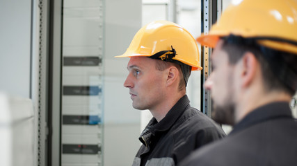 Wall Mural - two maintenance engineer work on relay protection system
