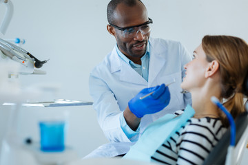 Clear explanation. Charming young woman listening to her male dentist attentively while he explaining the treatment protocol to her