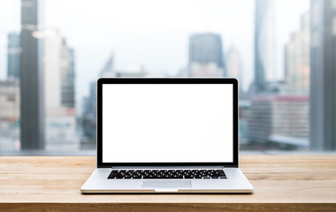 Wall Mural - Modern computer,laptop with blank screen on wood table with office window view