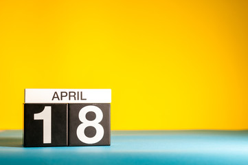 Sticker - April 18th. Day 18 of april month, calendar on table with yellow background. Spring time, empty space for text