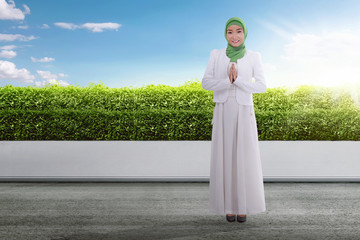 Wall Mural - Young asian muslim woman in headscarf praying