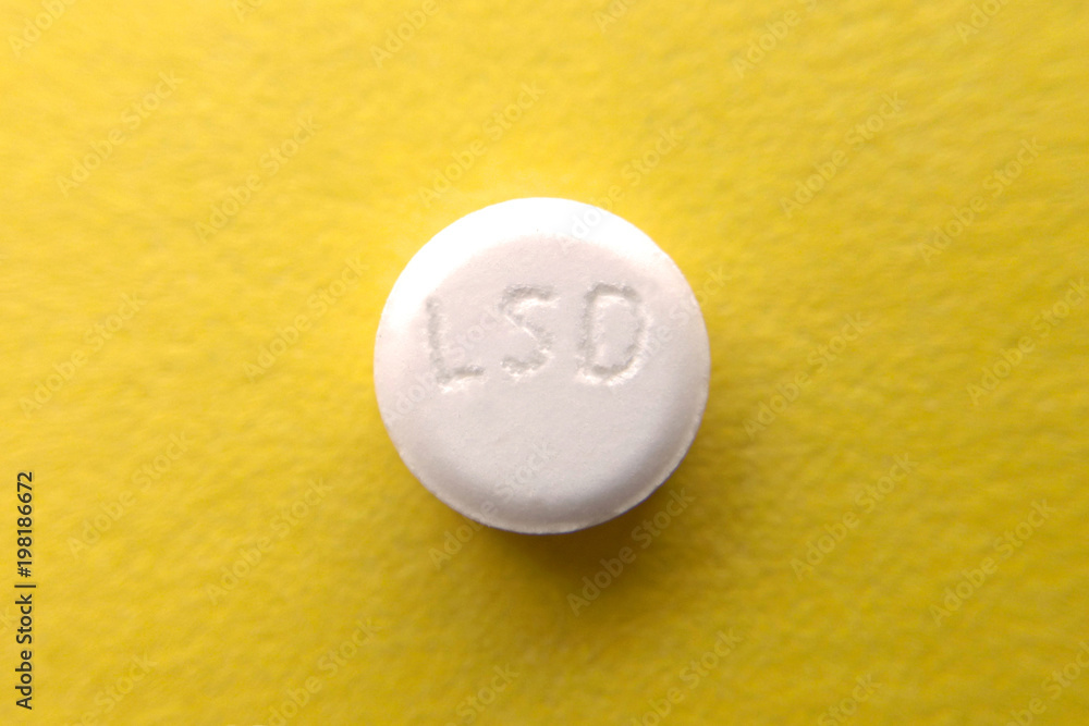 Tablet LSD yellow background close-up