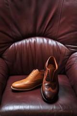 leather handmade shoes on a leather sofa with a dark color