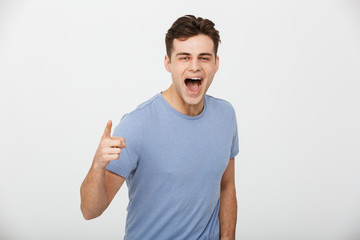 Poster - Portrait of an excited young man pointing finger at camera