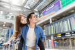 Young asian couple having fun and playing at airport terminal. Happy asia lovers are traveling honeymoon trip by airplane. Asia tourism, or holiday vacation travel concept.