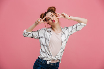 Canvas Print - Portrait of a funny young girl showing peace gesture