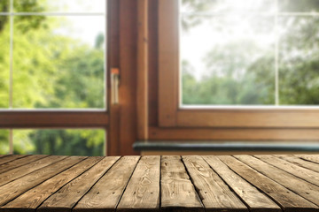 Wall Mural - old brown wooden table top with copy space and wooden window background in home interior. green tree