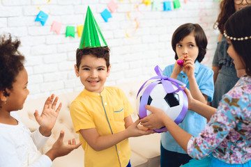 Happy birthday boy receives football ball as birthday gift. Happy birthday party.