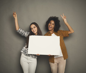 two girlfriends holding blank white banner
