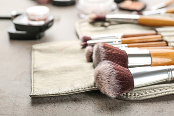 Wall Mural - Brushes of professional makeup artist in  leather case on table